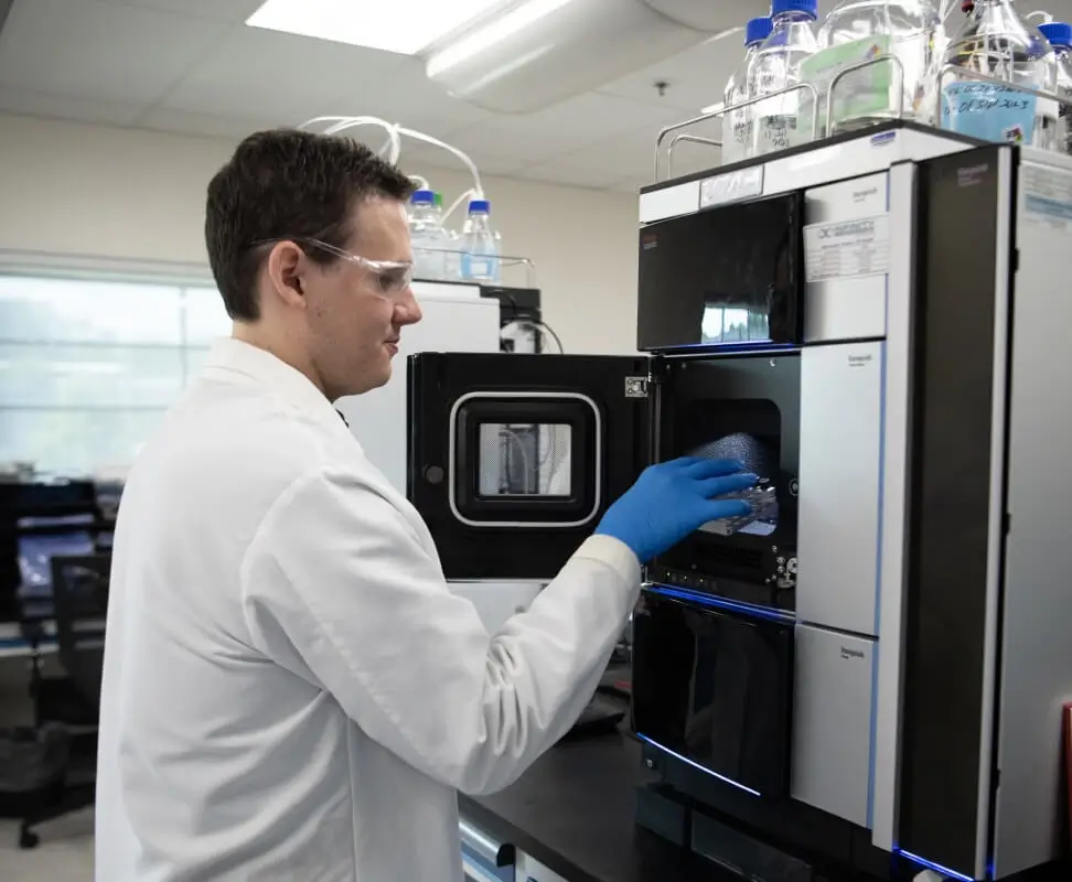 Male scientists interacting with analytical testing equipment