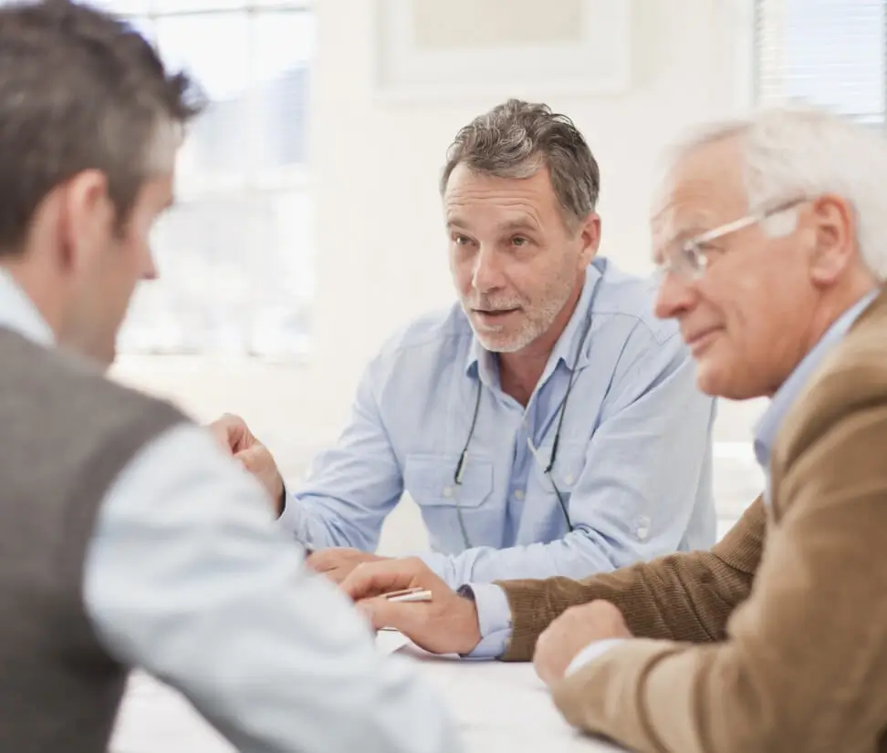 Three male executives talking around a table